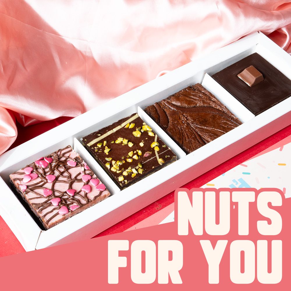 A long brownie box with 4 different flavoured brownies. 1 strawberry and nutella flavoured brownie, 1 pistachio brownie, 1 nutella brownie and 1 kinder brownie. 